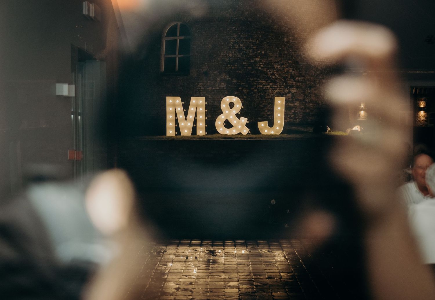 Illuminated wedding signage with initials M&L displayed in a romantic evening setting.