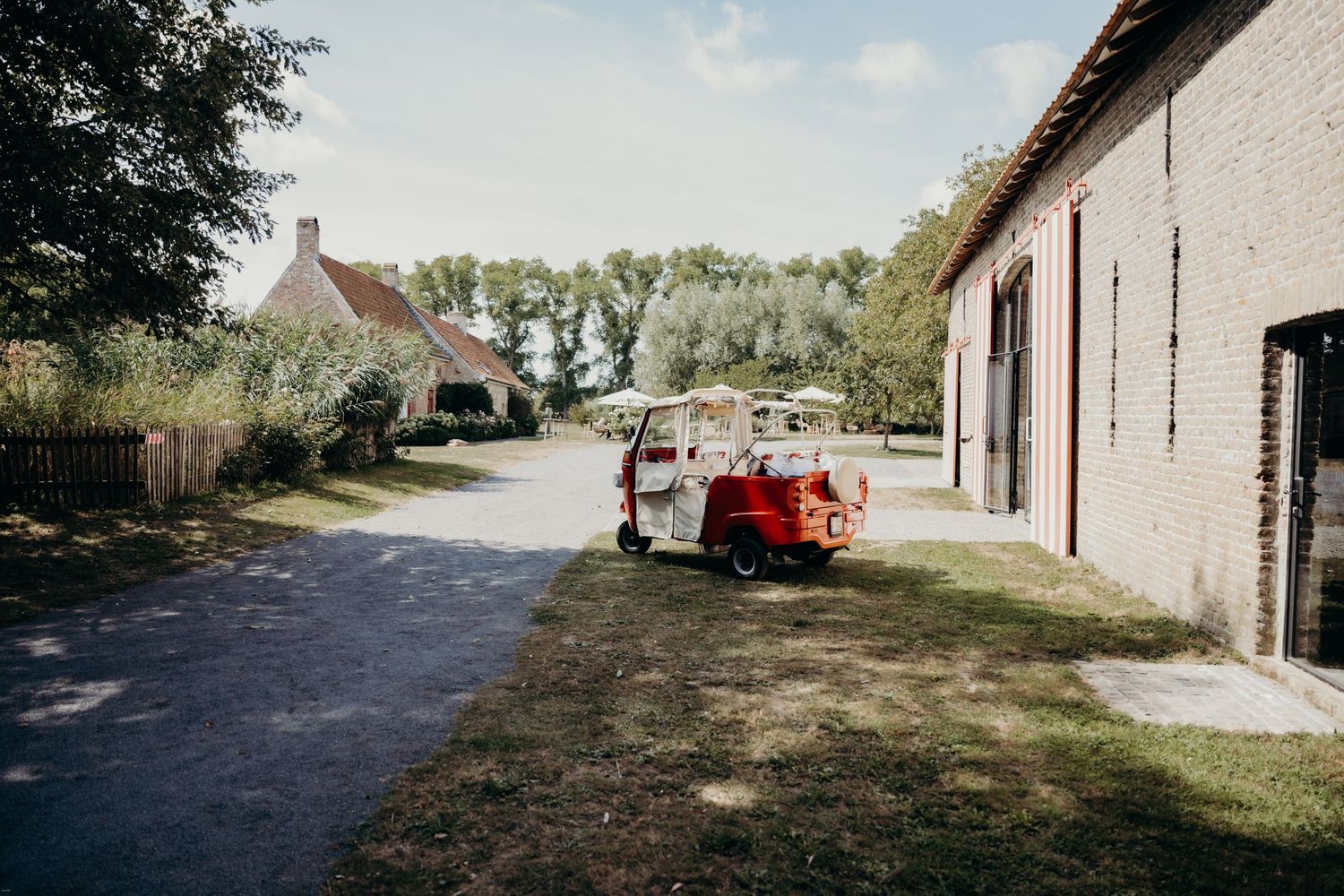 Rural countryside setting with traditional farm buildings and dirt path.