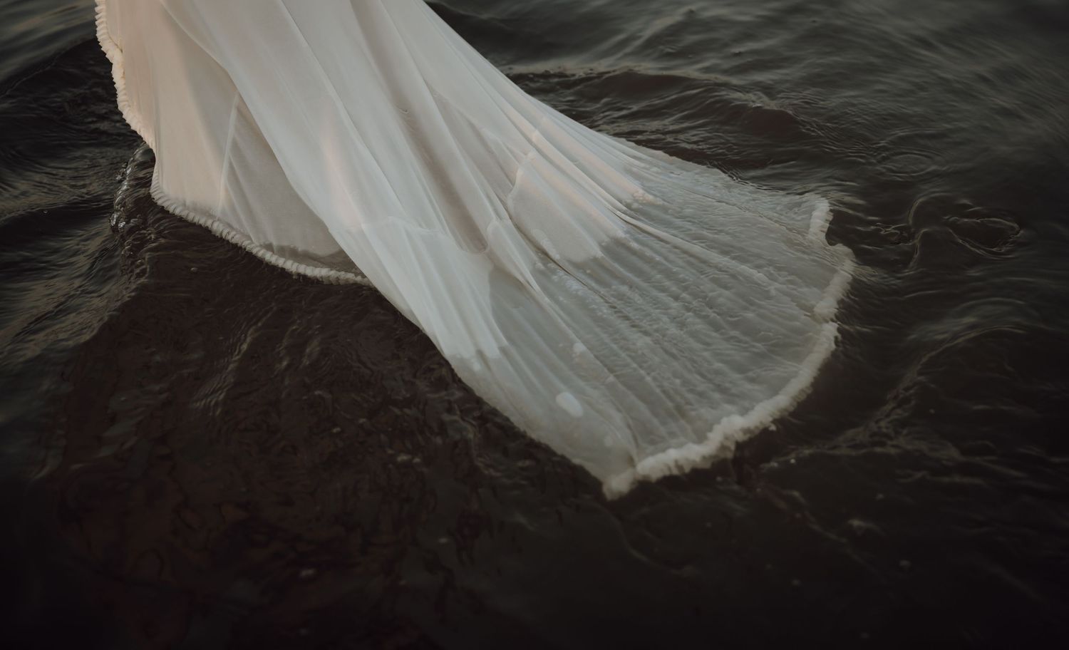 A dramatic series of photos showing a white flowing fabric or dress billowing against a dark moody background.