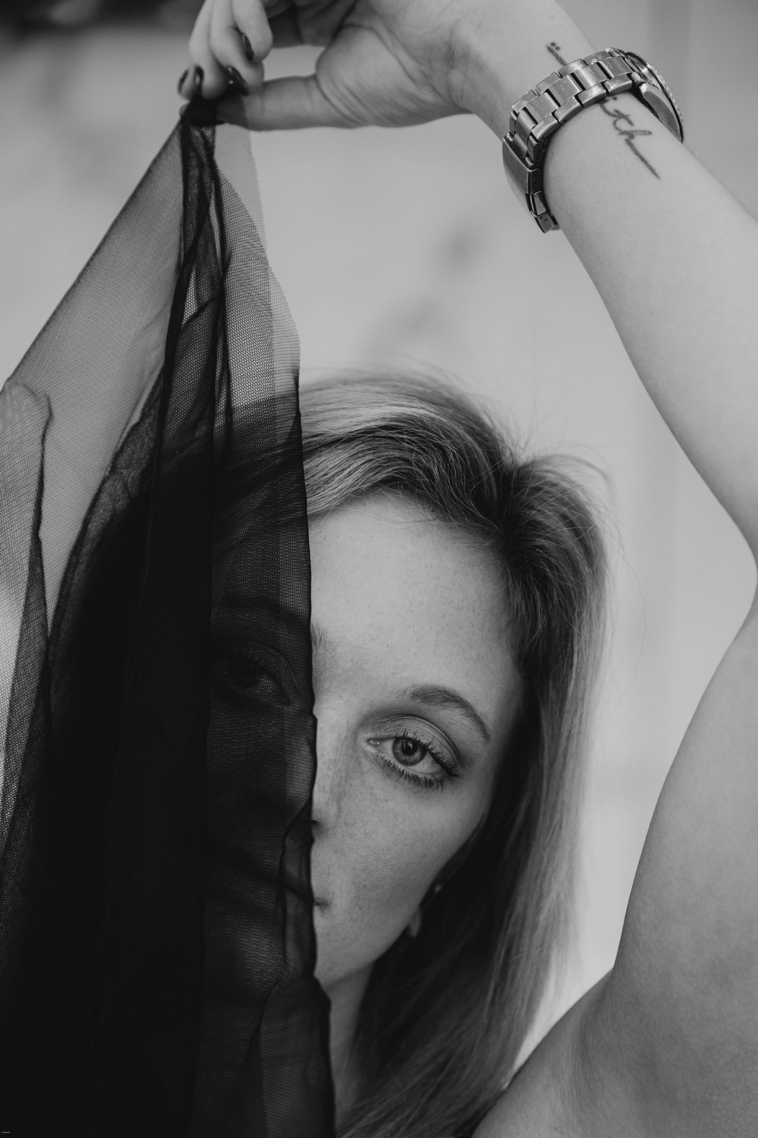 A black and white artistic photo series showing a person's face partially obscured by dark fabric in different poses.