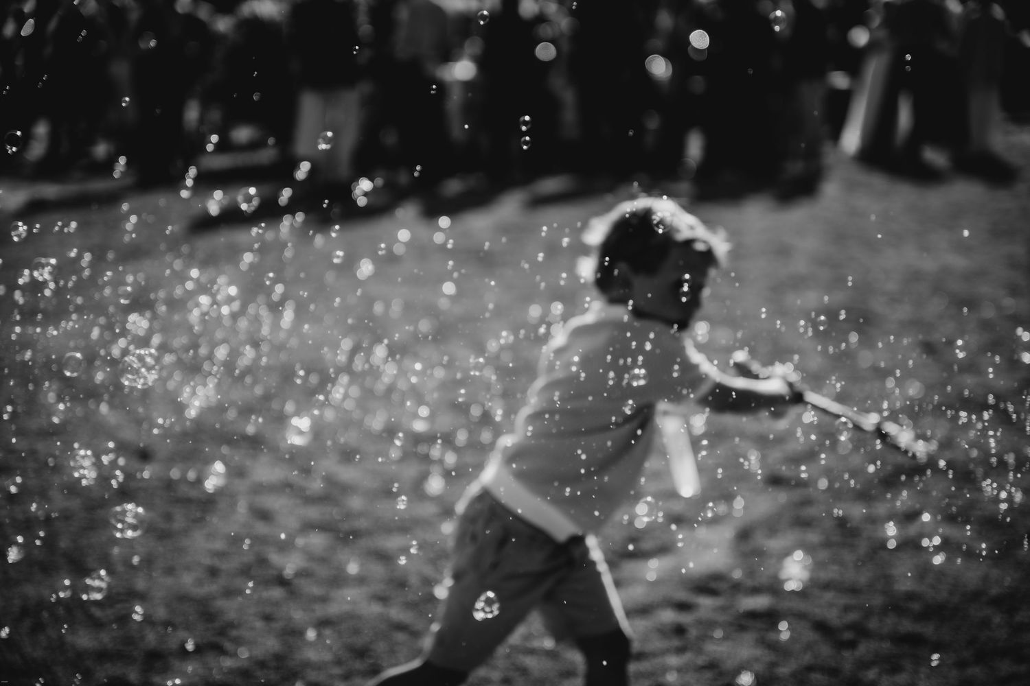 Artistic black and white capture of soap bubbles floating against dark background.