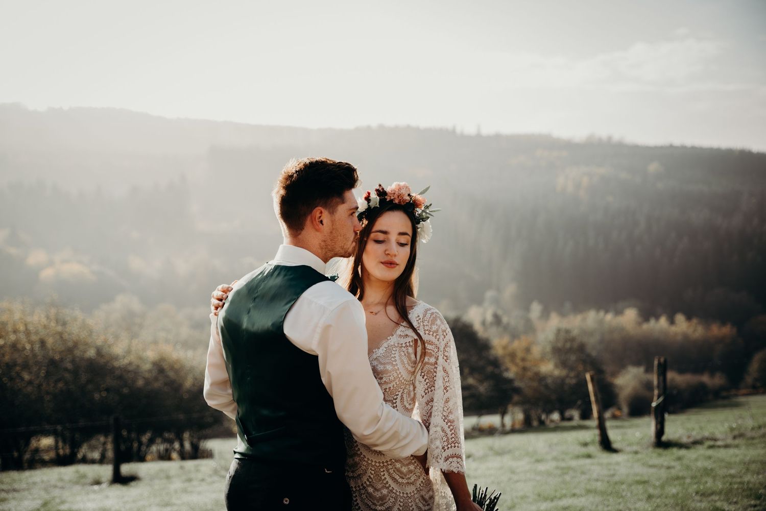 Intimate wedding couple moment captured against a misty mountain backdrop.