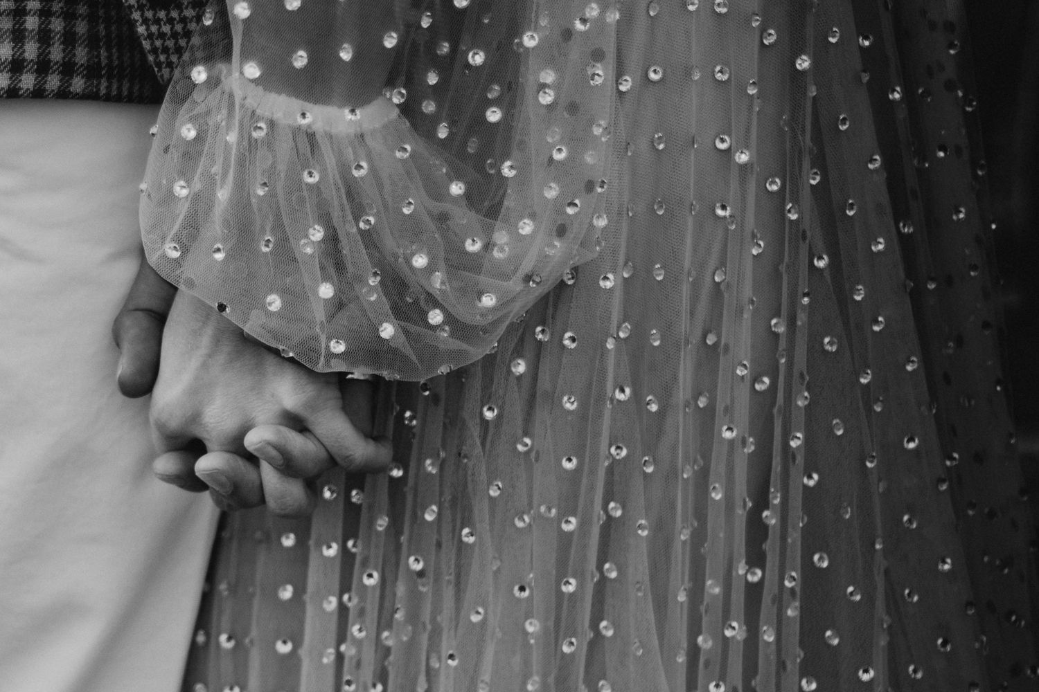 Detail shot of delicate polka dot pattern on sheer wedding dress fabric.