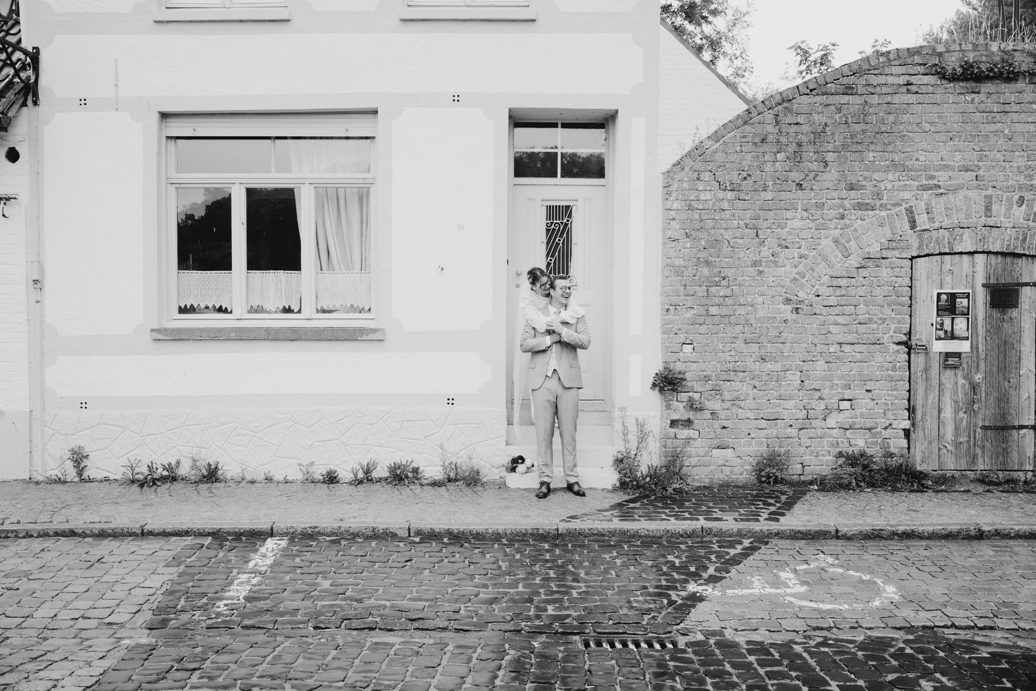 Panoramic view of a white stone building exterior with multiple windows and doors.