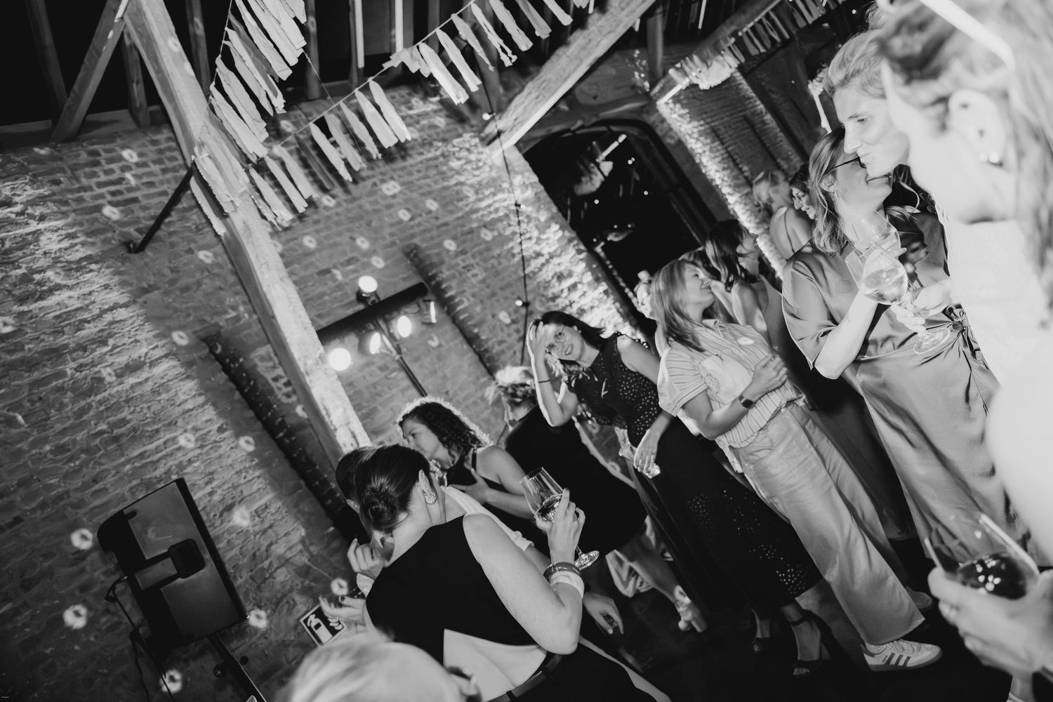 Black and white overhead shot of wedding guests dancing at a reception.