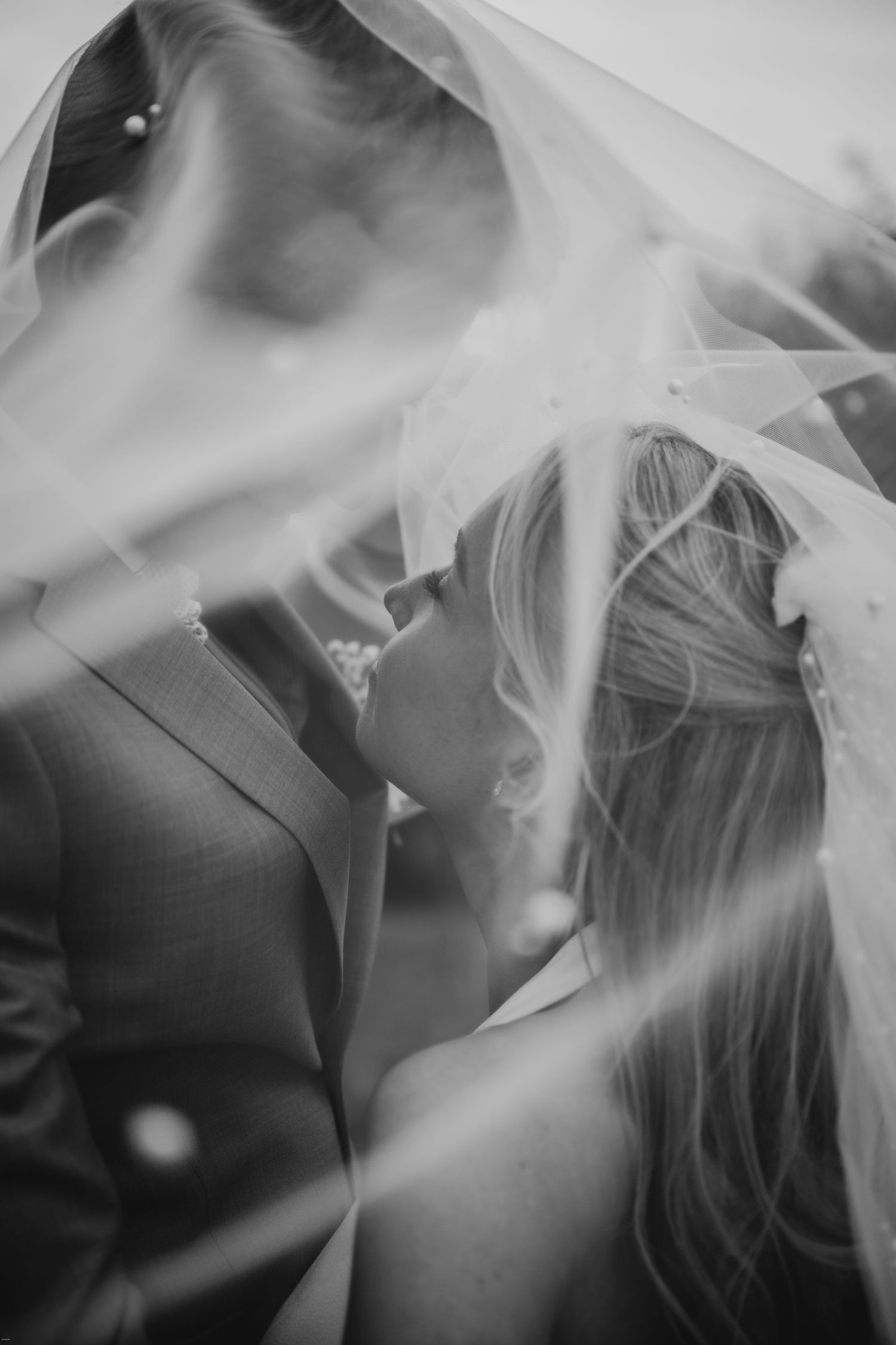 Ethereal black and white photos with flowing wedding veil creating dreamy effects.