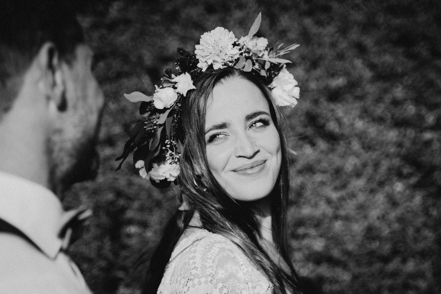 Black and white portraits show a joyful bride wearing a floral crown and lace dress.