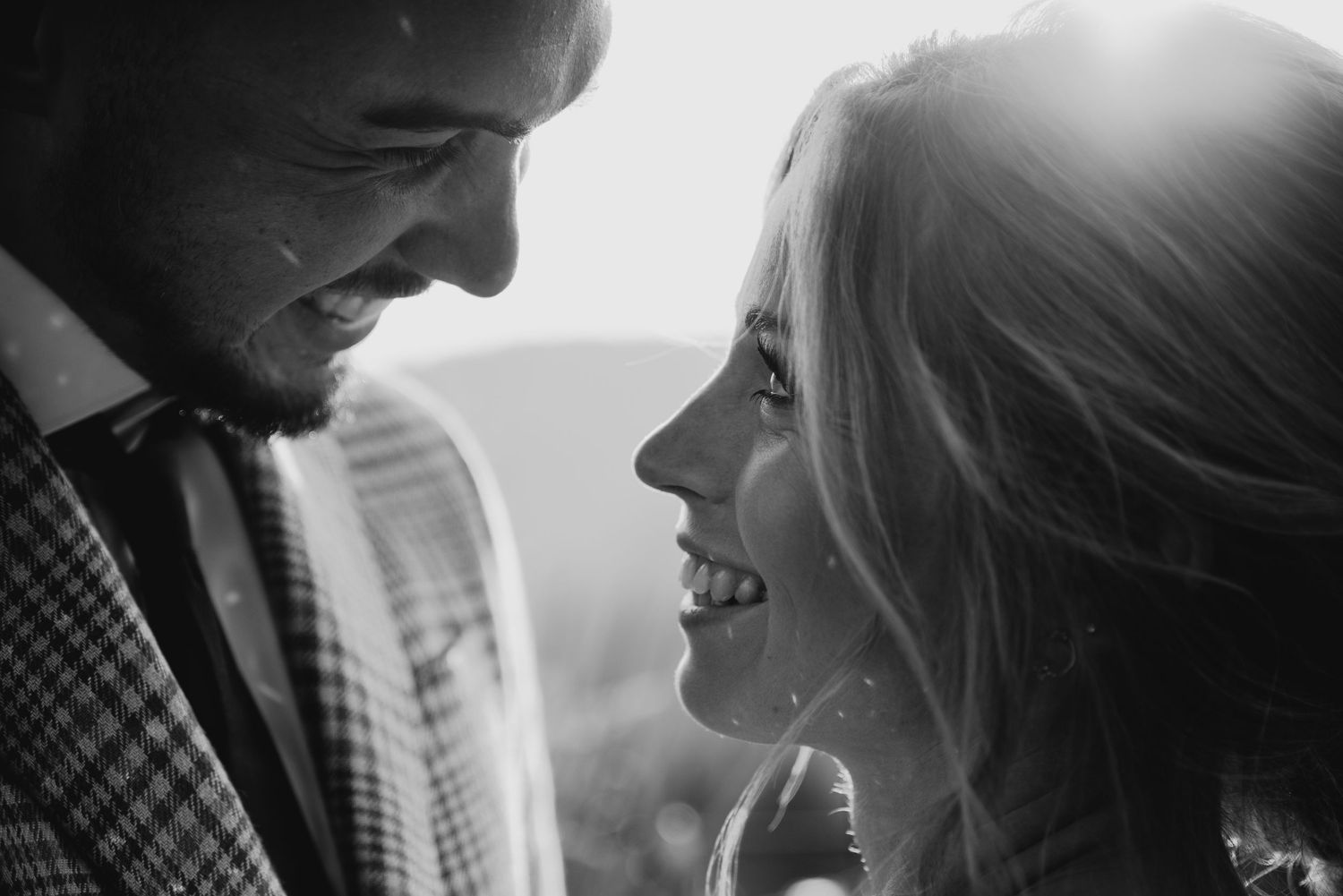 Intimate black and white portrait of a couple sharing a tender romantic moment.