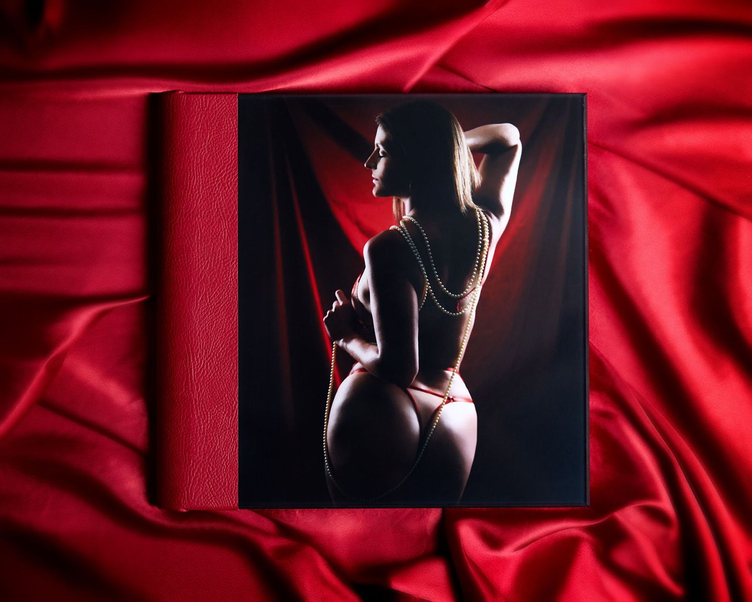 A red acrylic Luxury Boudoir Album, Charlotte, NC, showcasing a woman on the cover