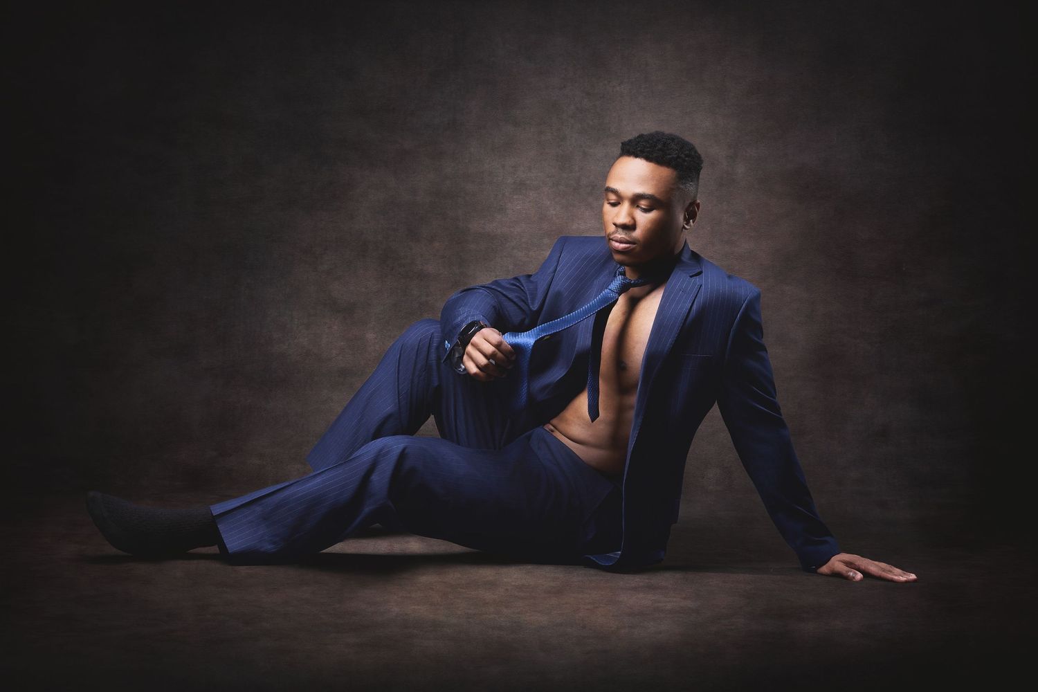 High-contrast studio portrait showcasing muscle tone and athletic form in a boudoir photography for men session in Charlotte, NC.