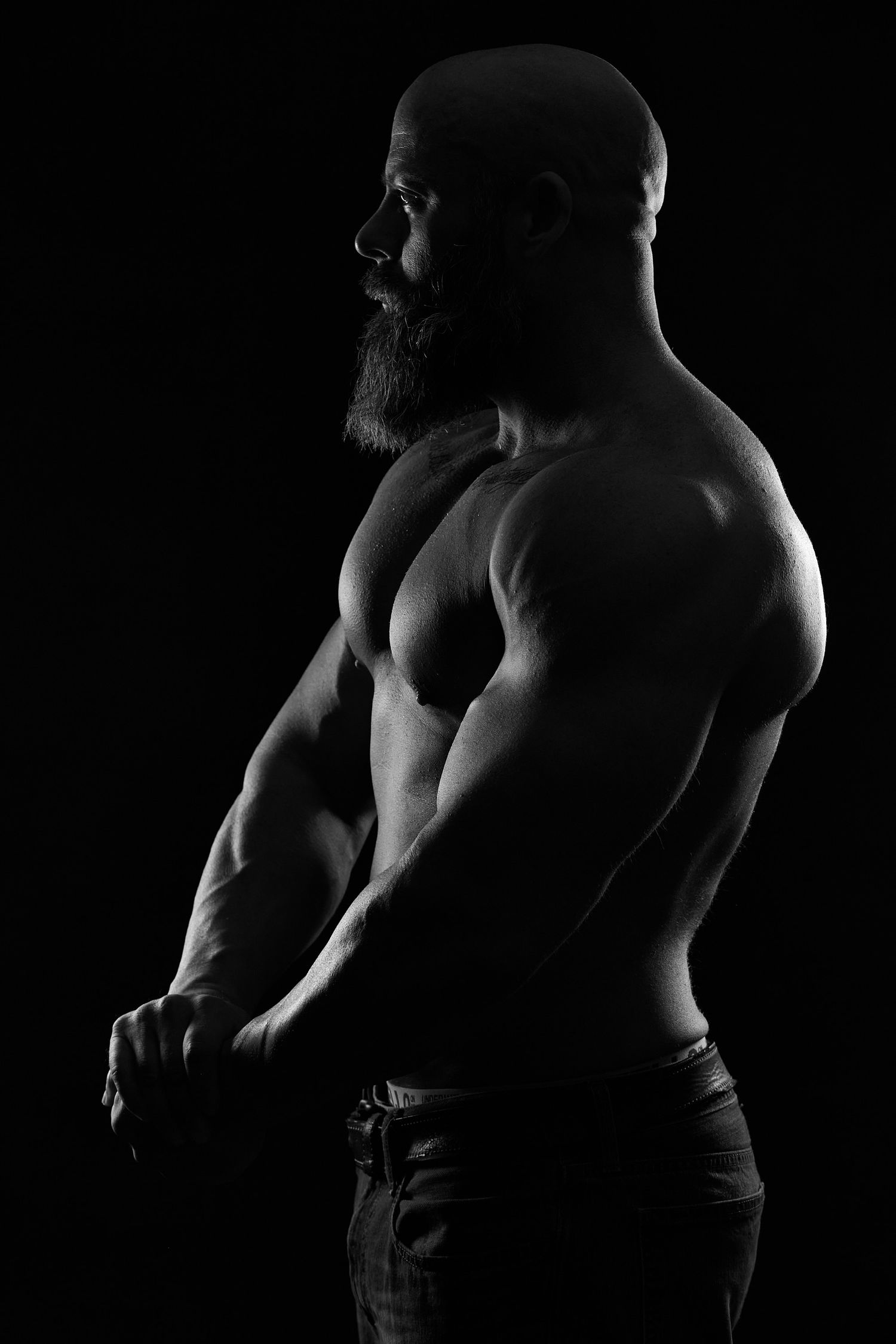 Artistic black and white male boudoir photography in Charlotte NC, highlighting muscle definition and strength.
