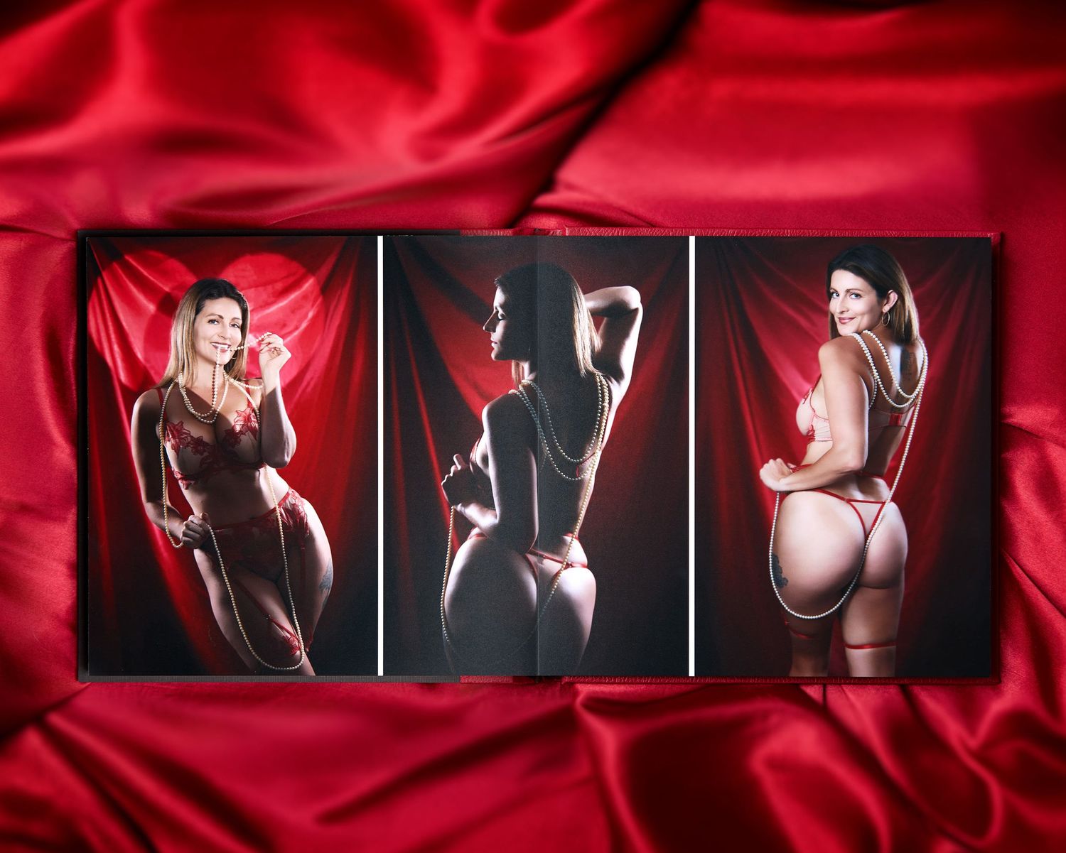 Luxury boudoir album lies open on red silk, displaying the inside of the album featuring a woman in red lingerie in Charlotte.