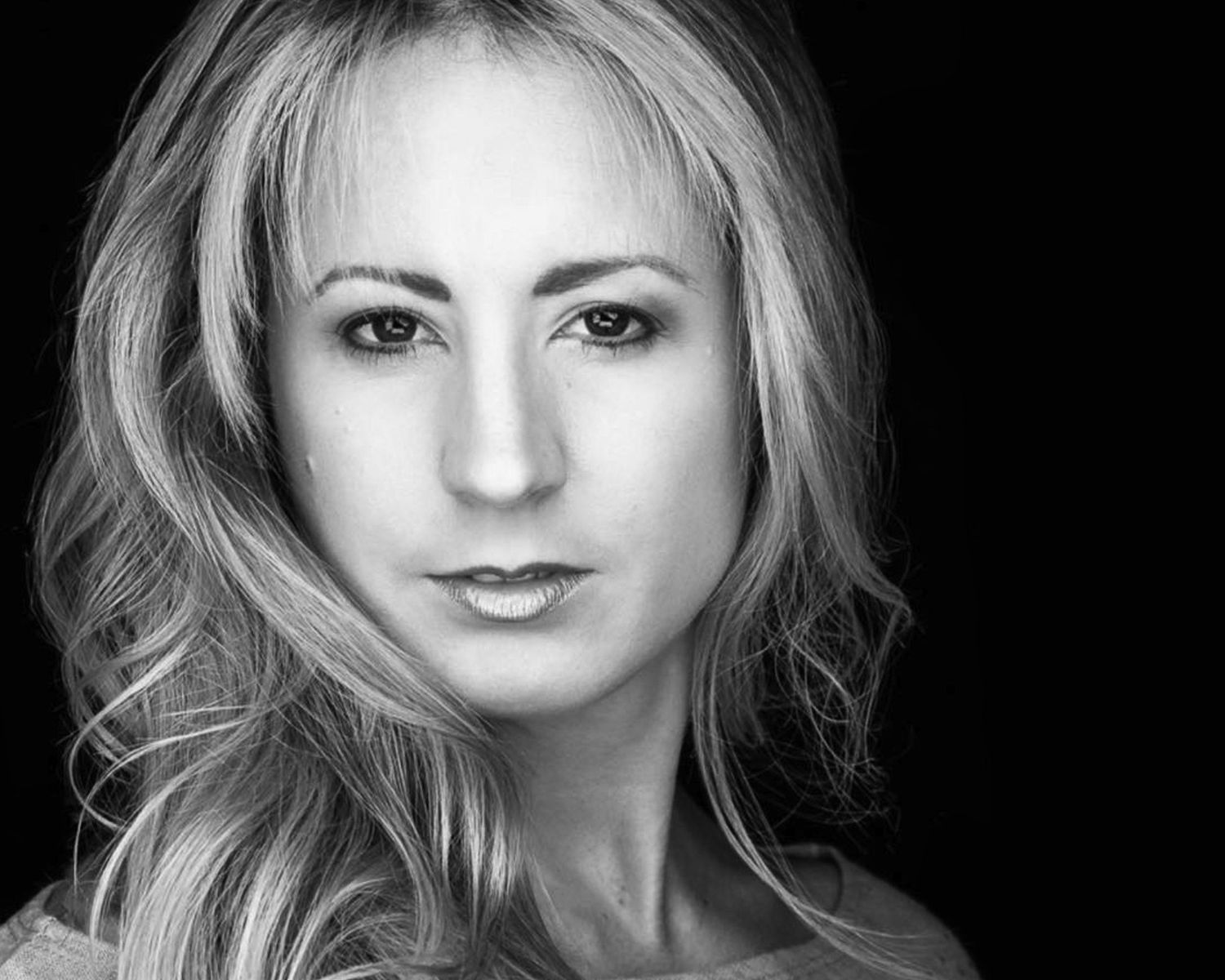 Award-winning Charlotte luxury boudoir photographer, Aleigha Tucker, posing for a professional headshot.