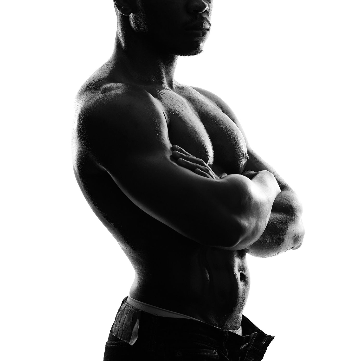 Close-up of sculpted abdominal and chest muscles in a luxury men's boudoir photoshoot capturing strength and athletic form.