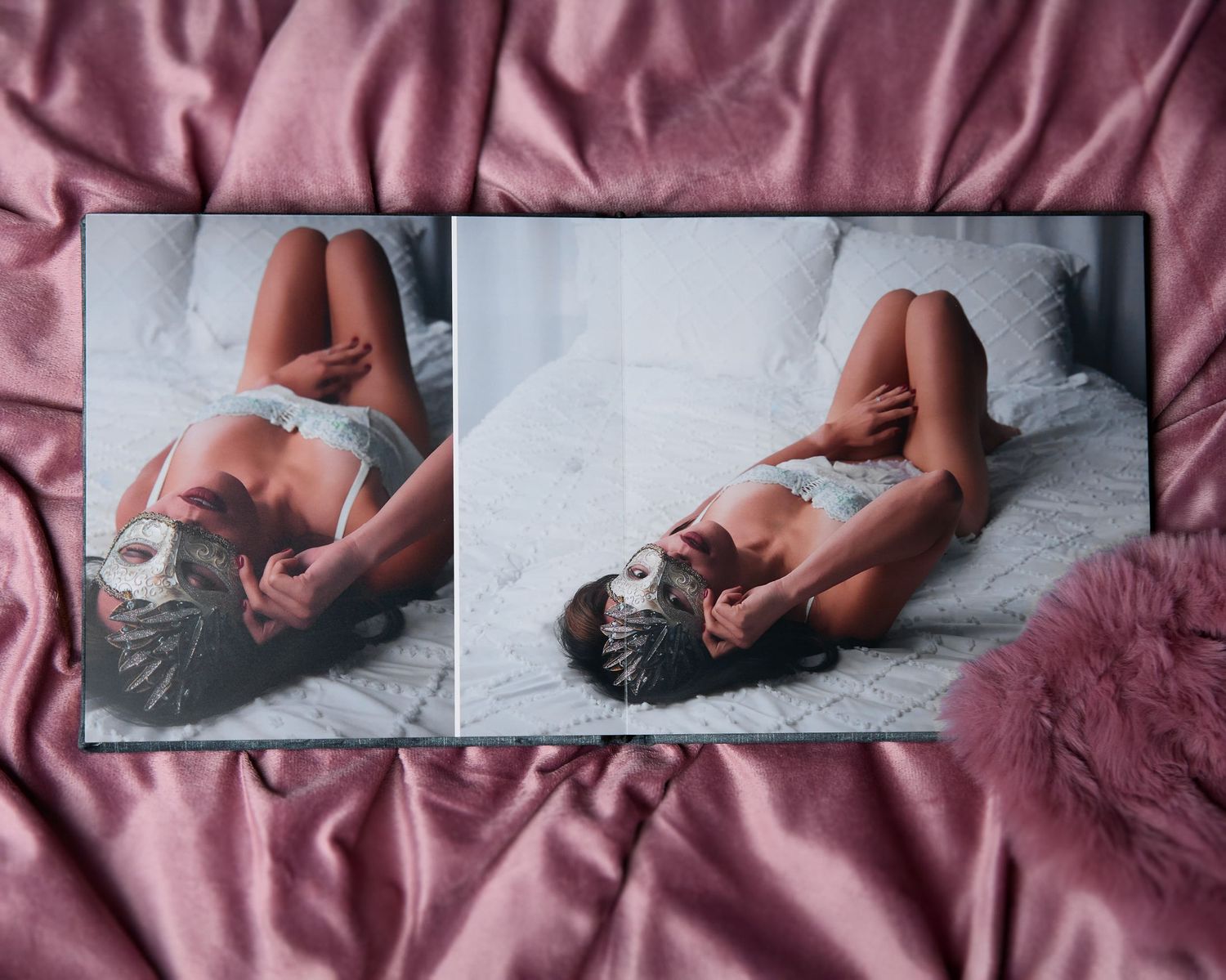 A boudoir album sits open on soft, pink fur, showcasing the inside of the album with layflat binding.