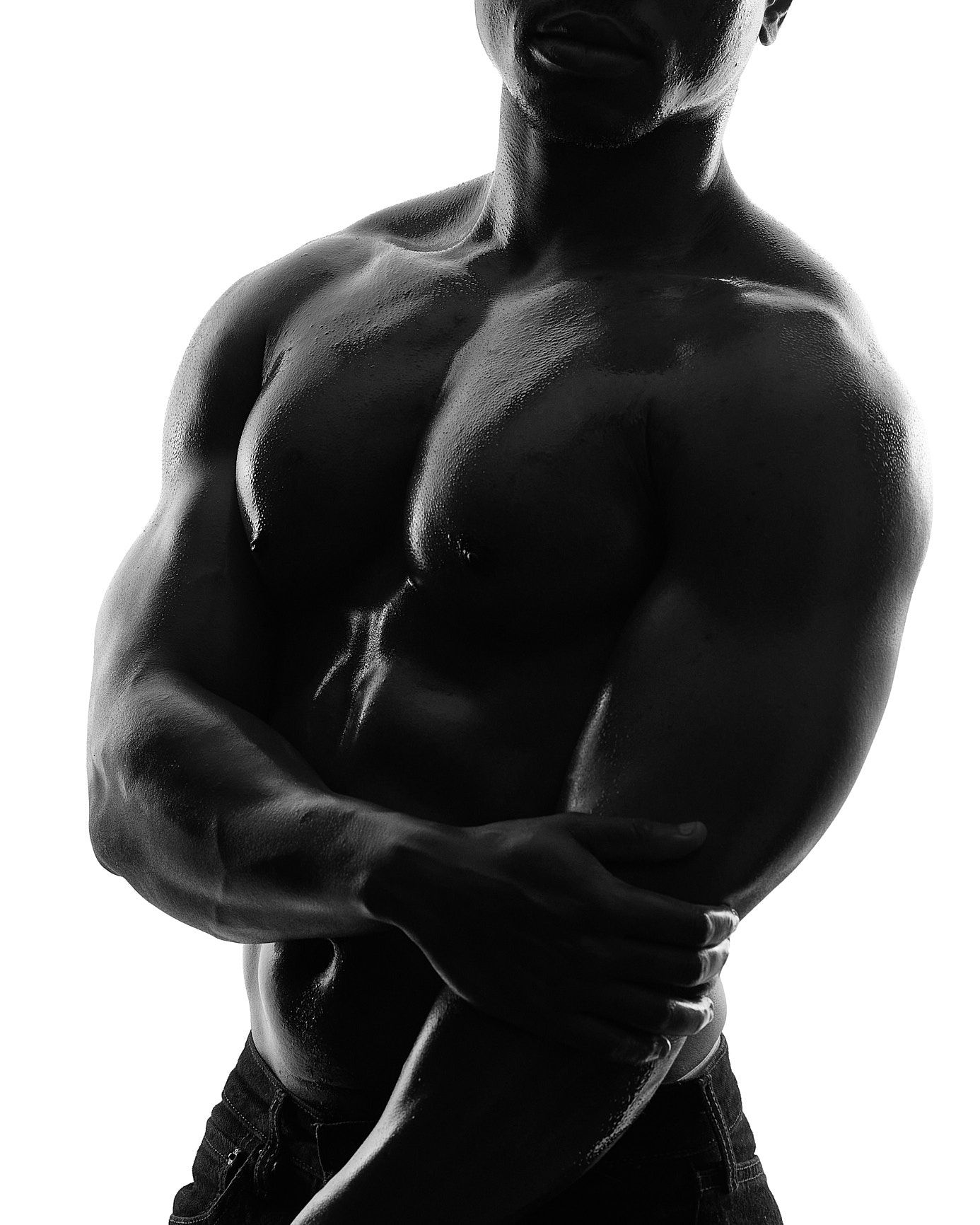 Muscular male torso with strong physical form and defined chest and core in high-contrast black-and-white male boudoir photography.