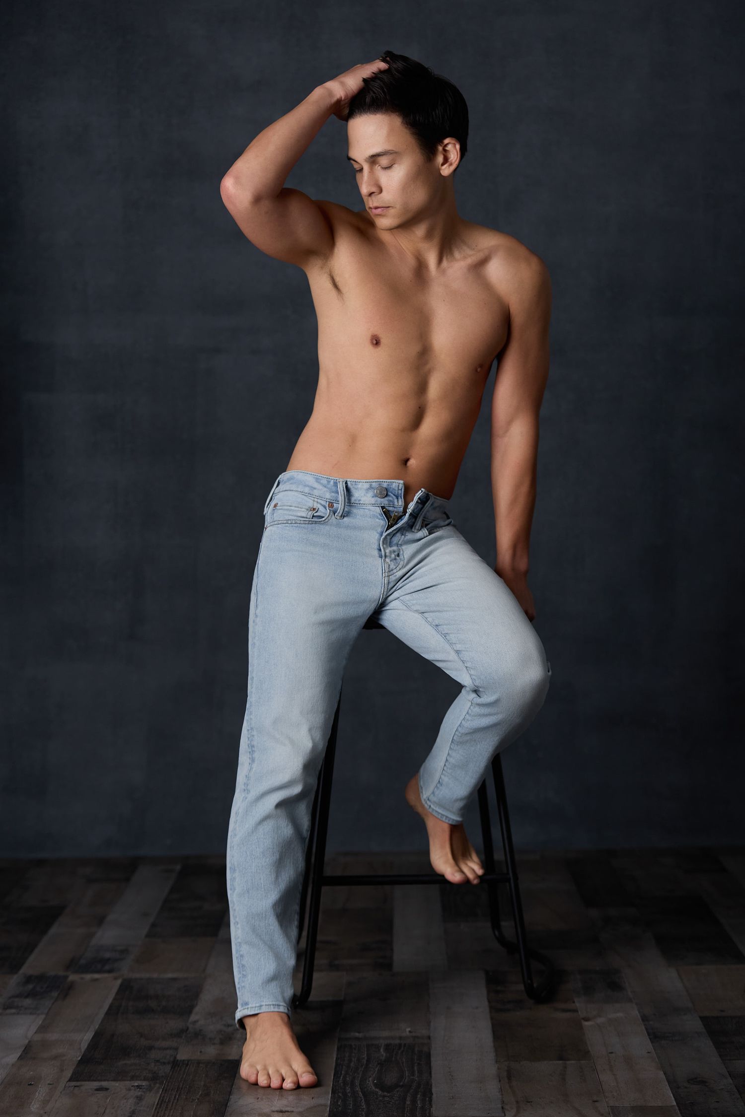A shirtless figure in light blue jeans poses artistically against a dark background in a series of dynamic movements.