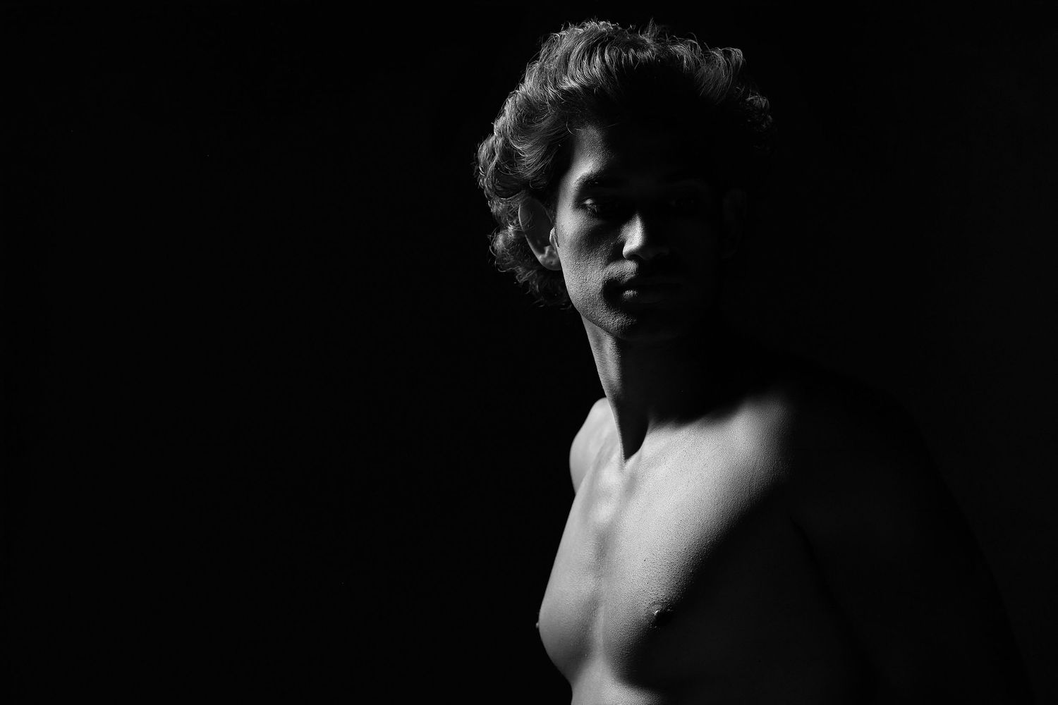Male boudoir photography in Charlotte, NC, featuring soft, sophisticated posing on a luxury textured backdrop.
