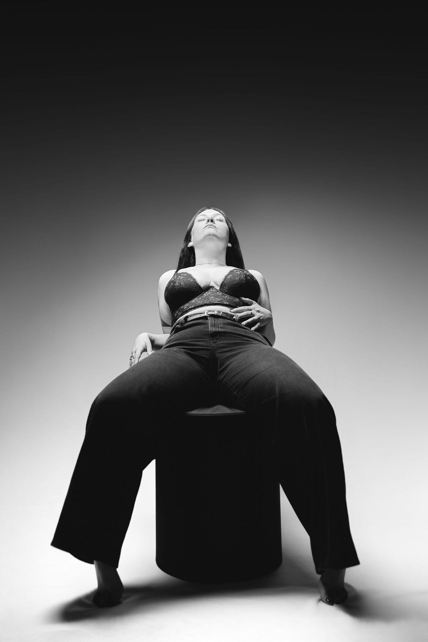 Black and white artistic photo series showing a person in dark clothing lying on the floor in dramatic poses.