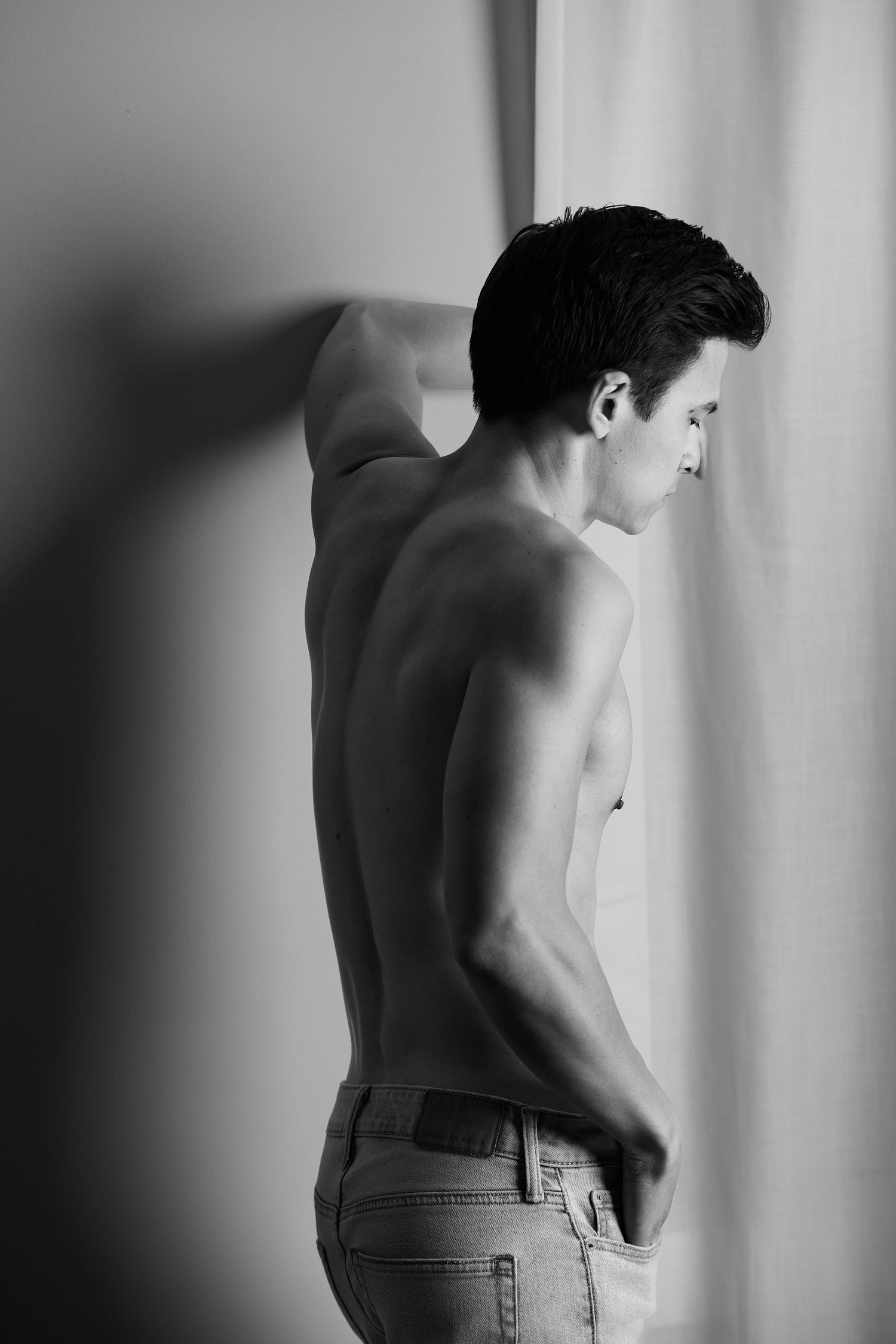 Minimalist monochrome portrait against white background with strong contrast.