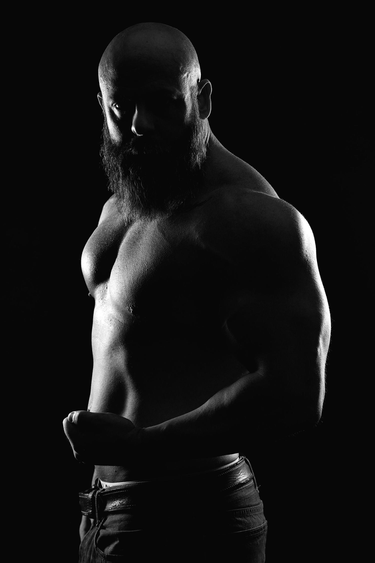 Black and white boudoir image of a male figure in dramatic lighting.