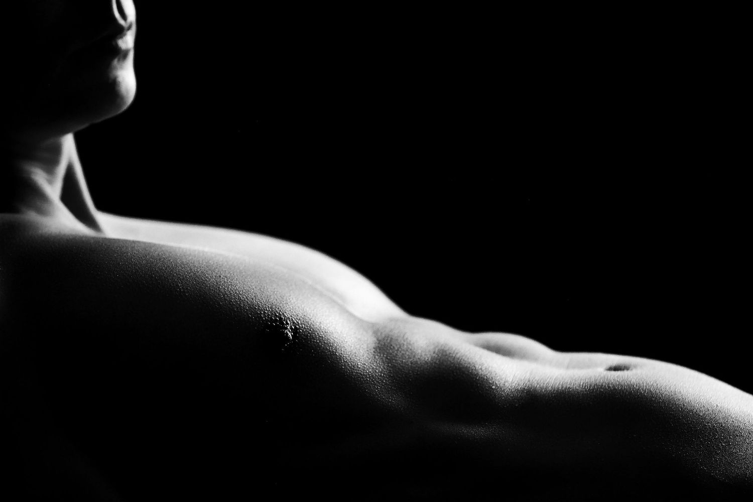 Artistic nude photography emphasizing natural curves and shadows.