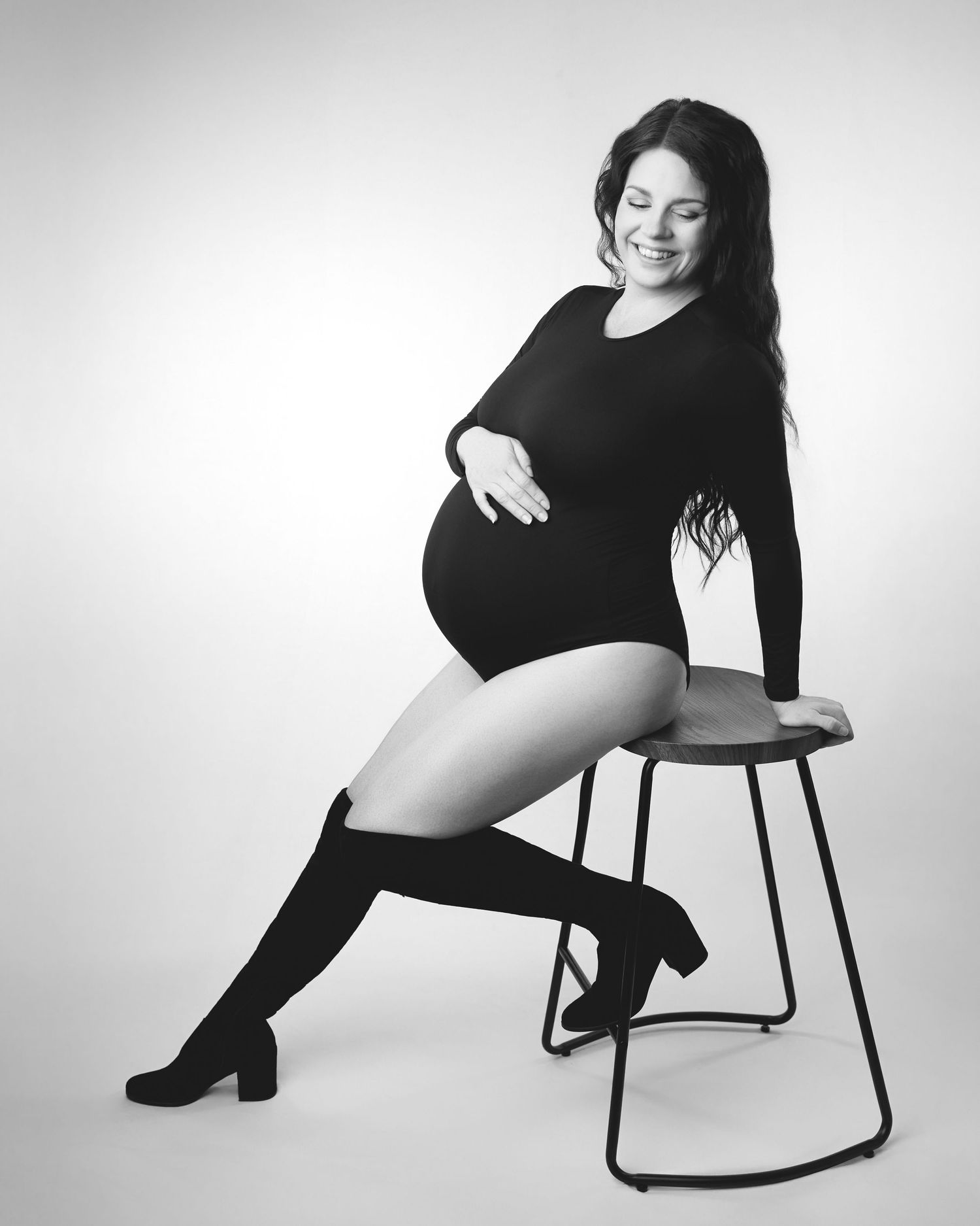 A woman posing for a maternity boudoir session.