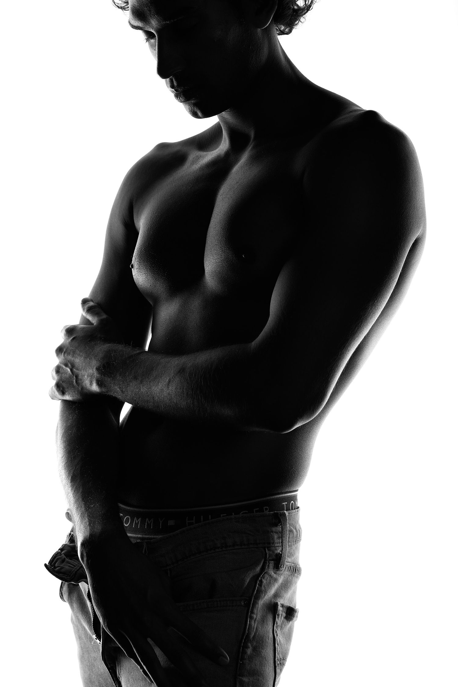 Empowering male boudoir photography in Charlotte featuring a man in a power pose and high-fashion lighting.