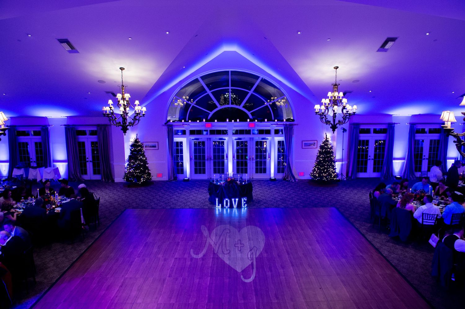 Spacious reception hall with purple ambient lighting and arched windows creating a stunning atmosphere.