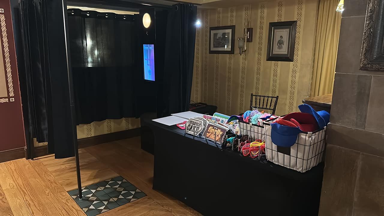 A merchandise display table in a dimly lit room with wood paneling and black curtains.