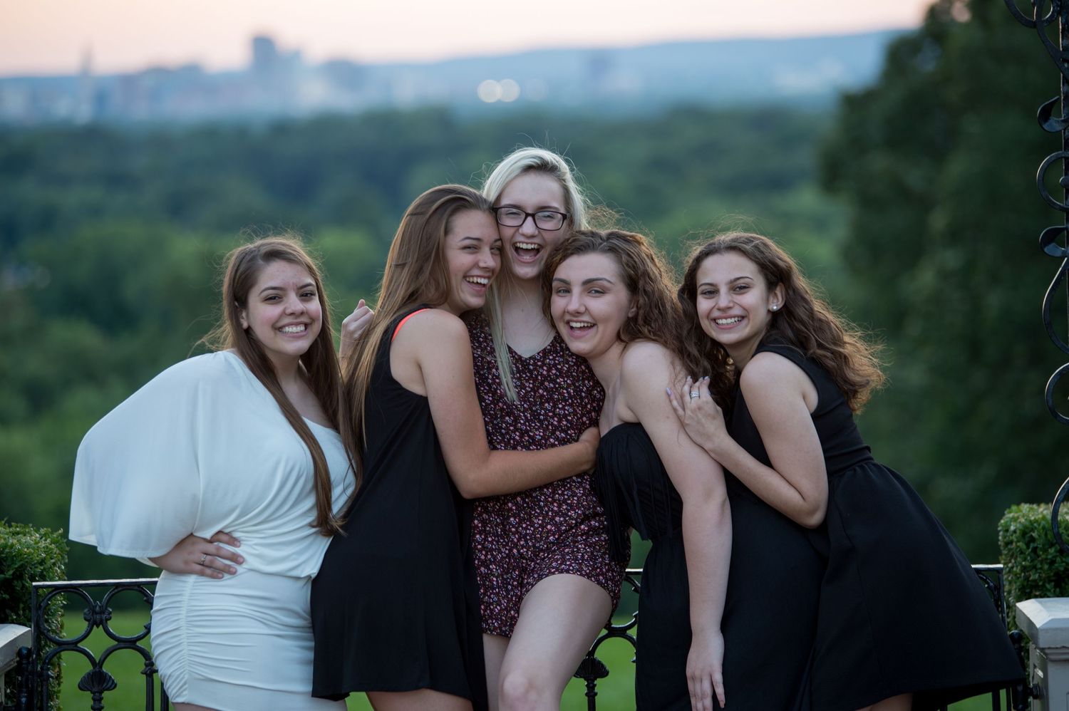 Friends gather for sunset photos in casual dark clothing.