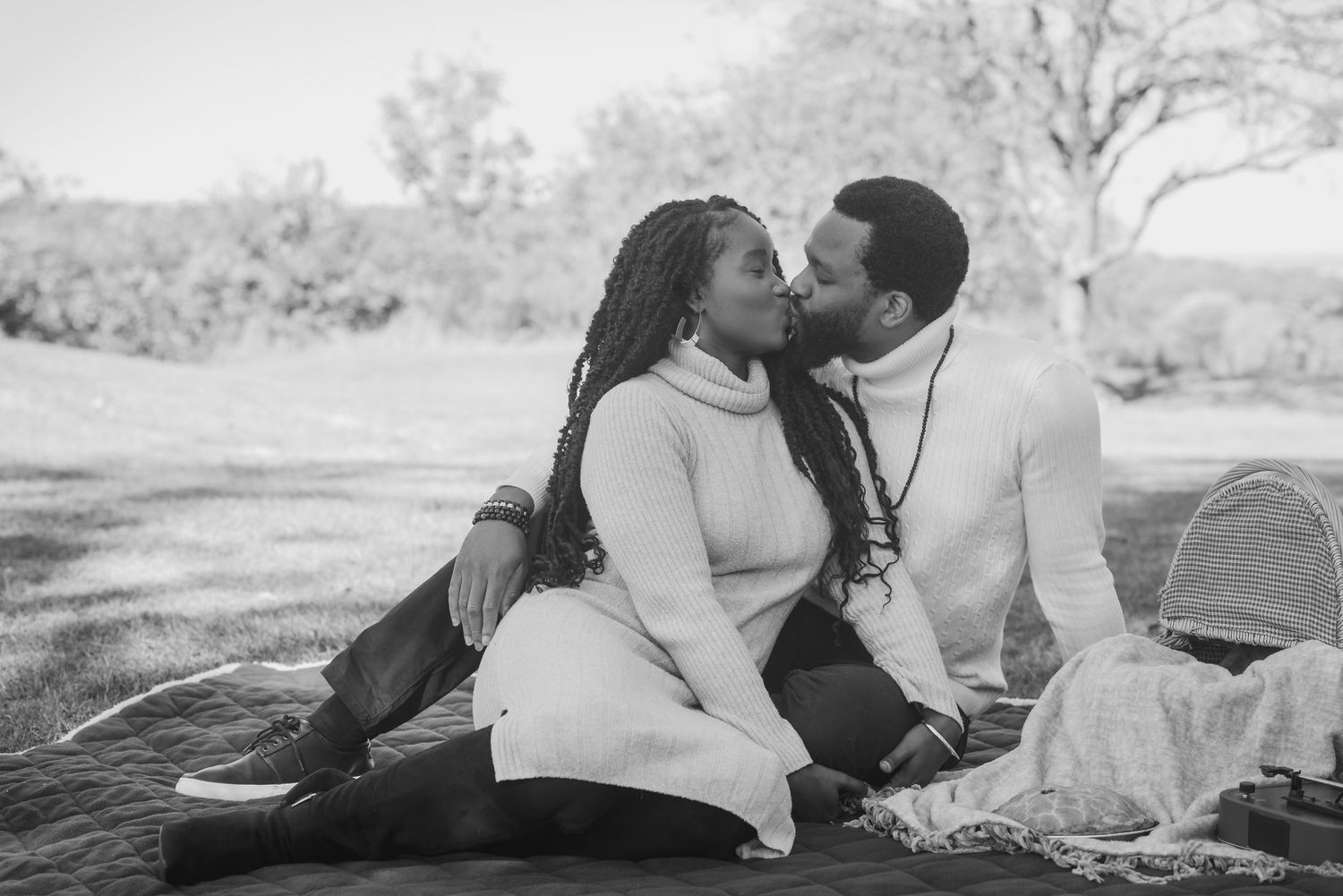 Romantic couple sharing intimate moment on blanket in black and white photography.