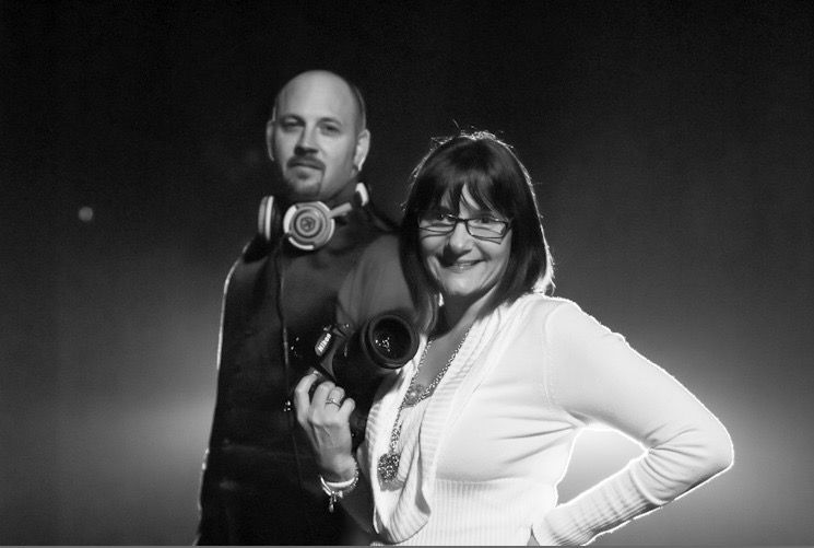 Black and white studio portrait with professional photography equipment visible.