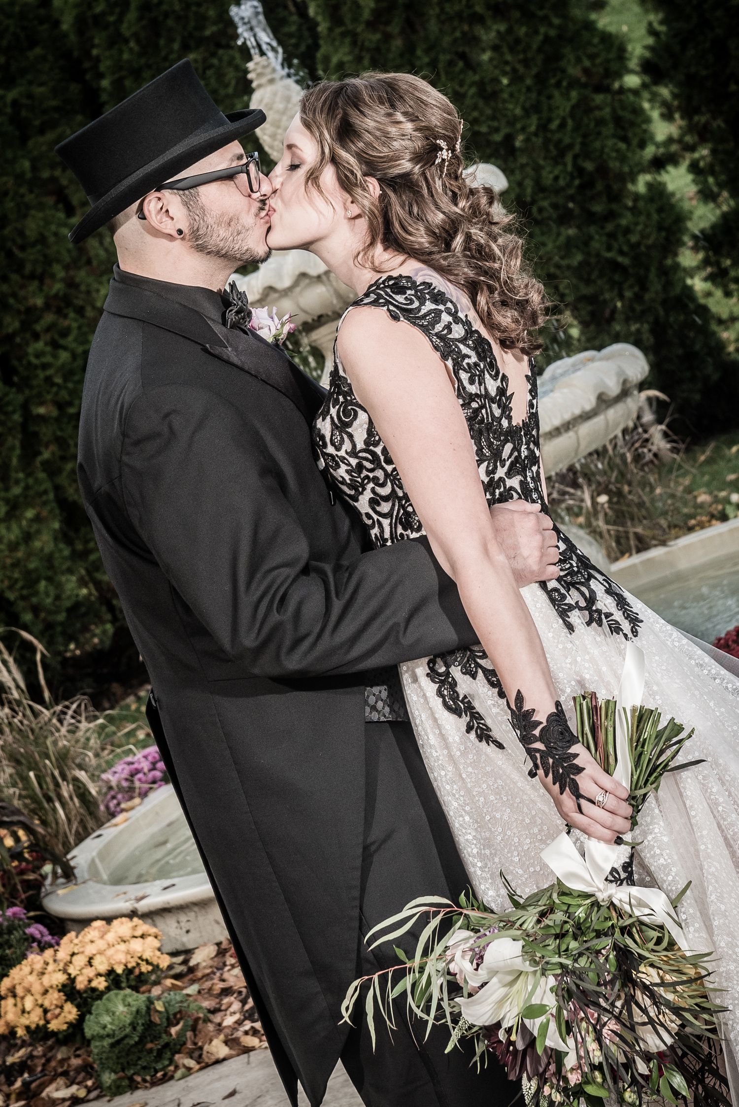 Intimate wedding portraits in a garden setting with black lace details on white dress.