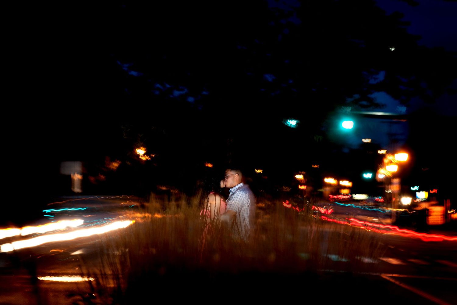 Night photography with streaking car lights creating colorful light trails on a dark road.