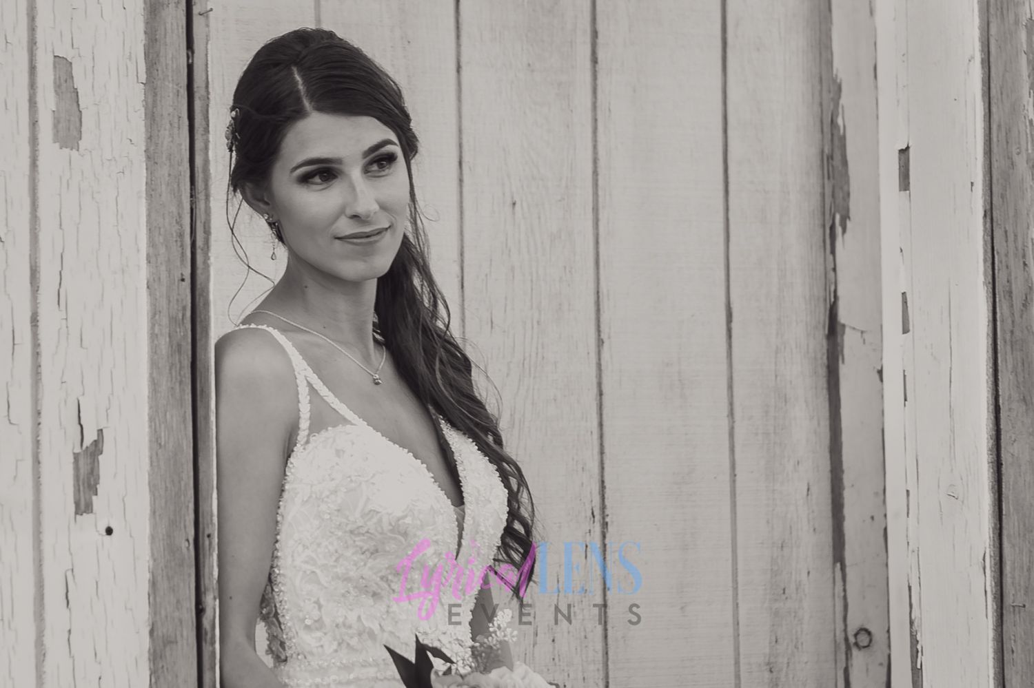 Black and white portrait session against a rustic wooden fence backdrop.