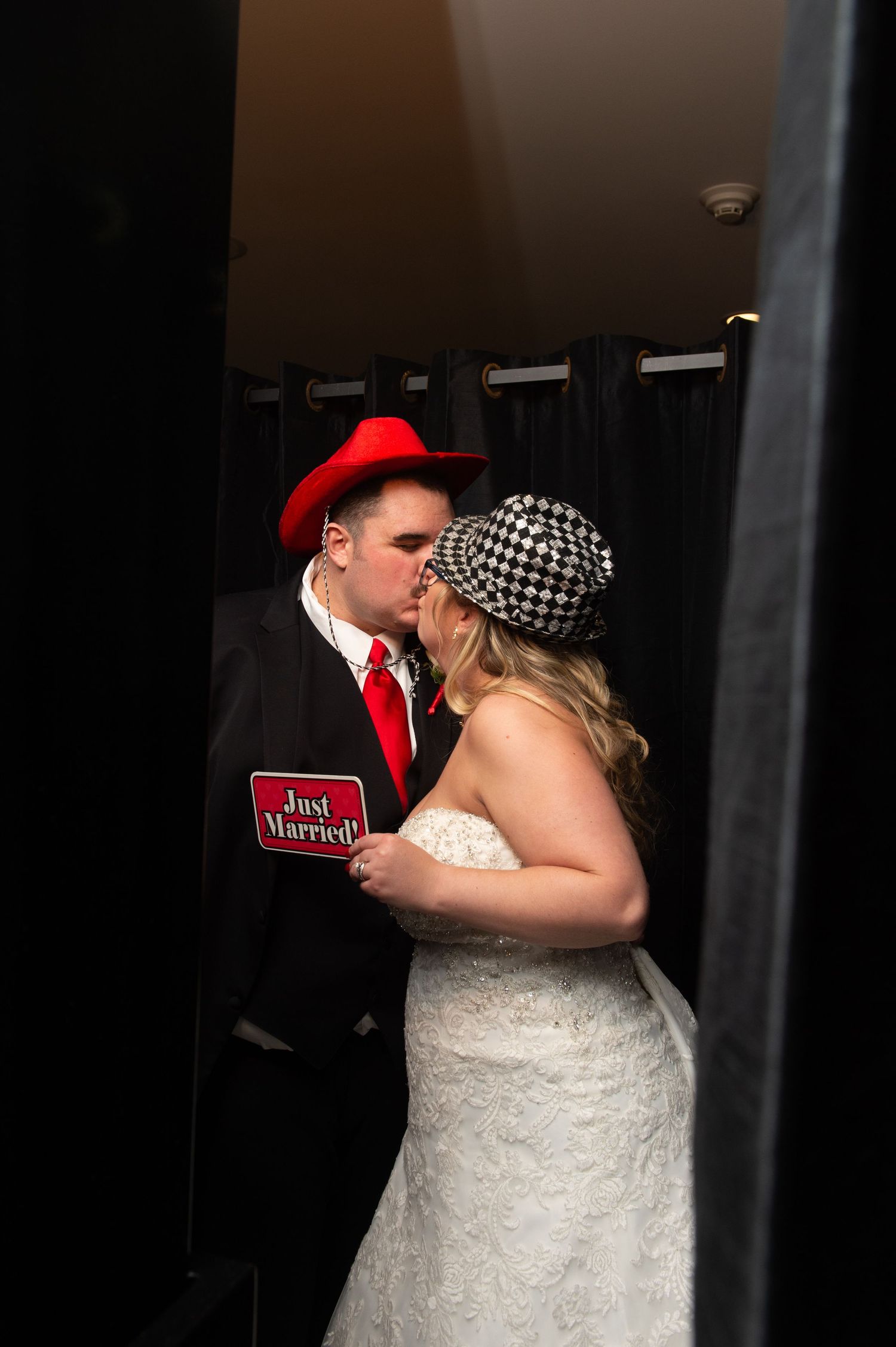 Couple sharing romantic moment near exit sign in dimly lit hallway.