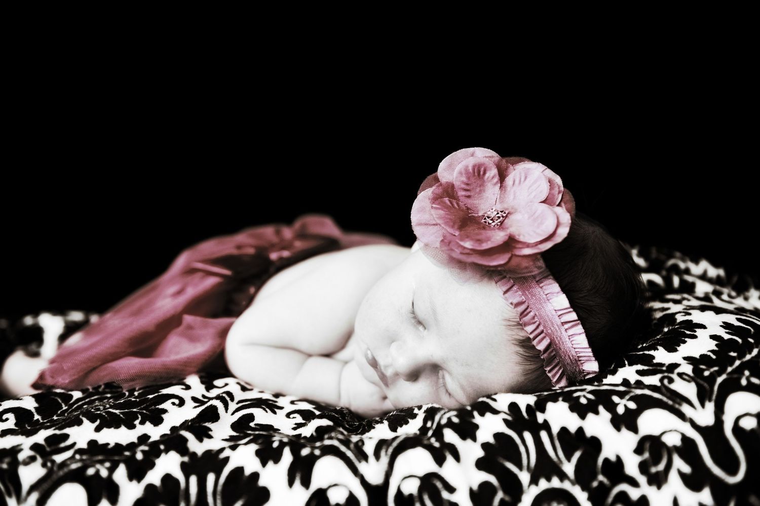 Artistic black and white portrait with pink flowers and decorative patterns.