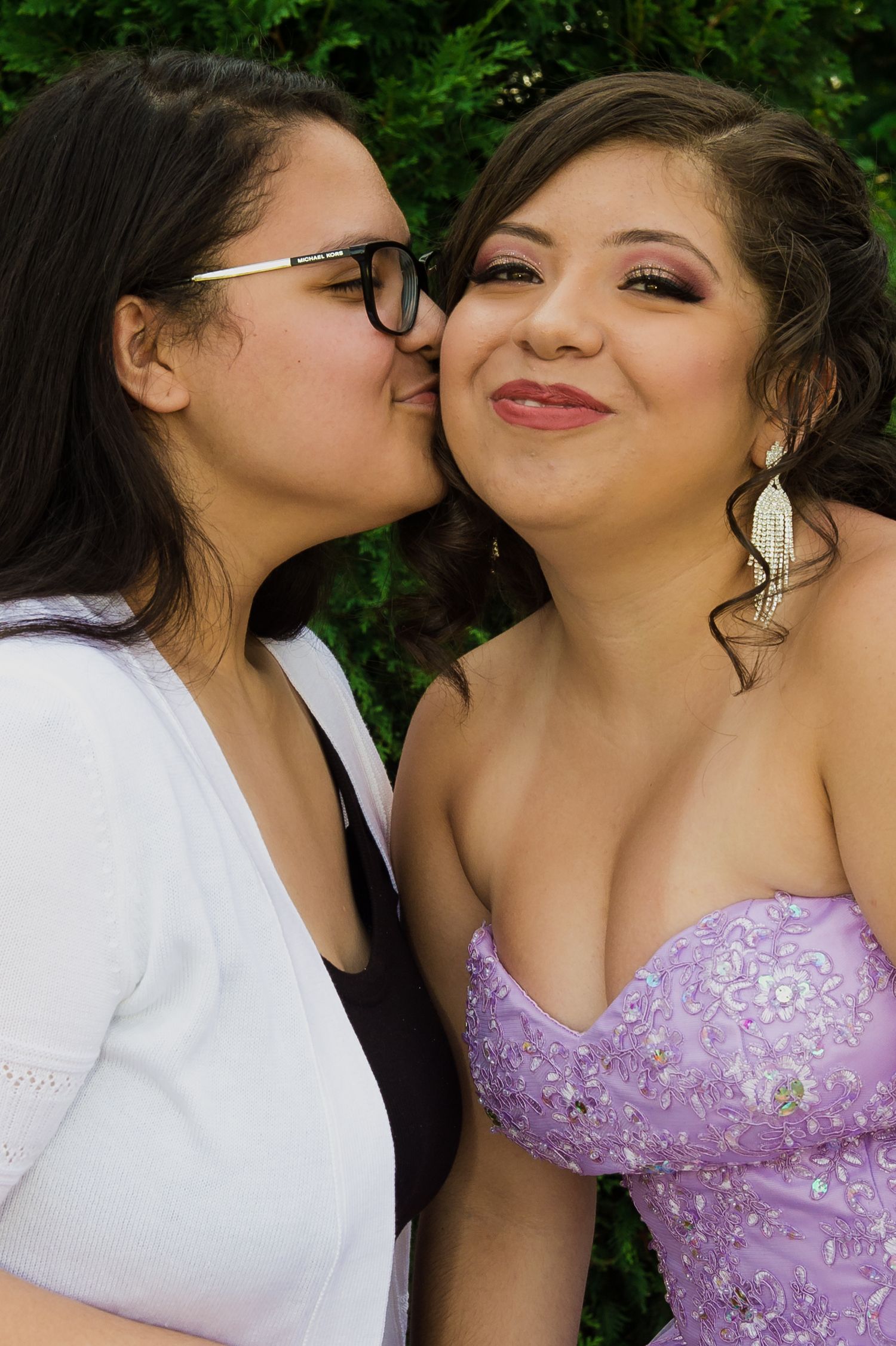 Two people share an intimate moment outdoors in formal attire.