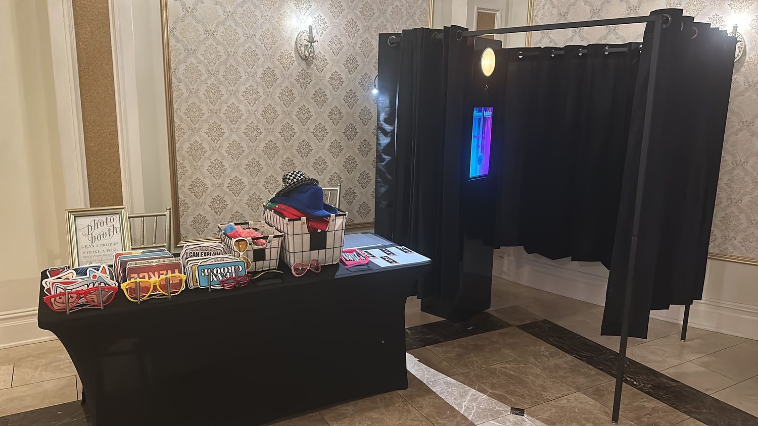 Empty banquet hall setup with elegant wallpaper and modern lighting fixtures.