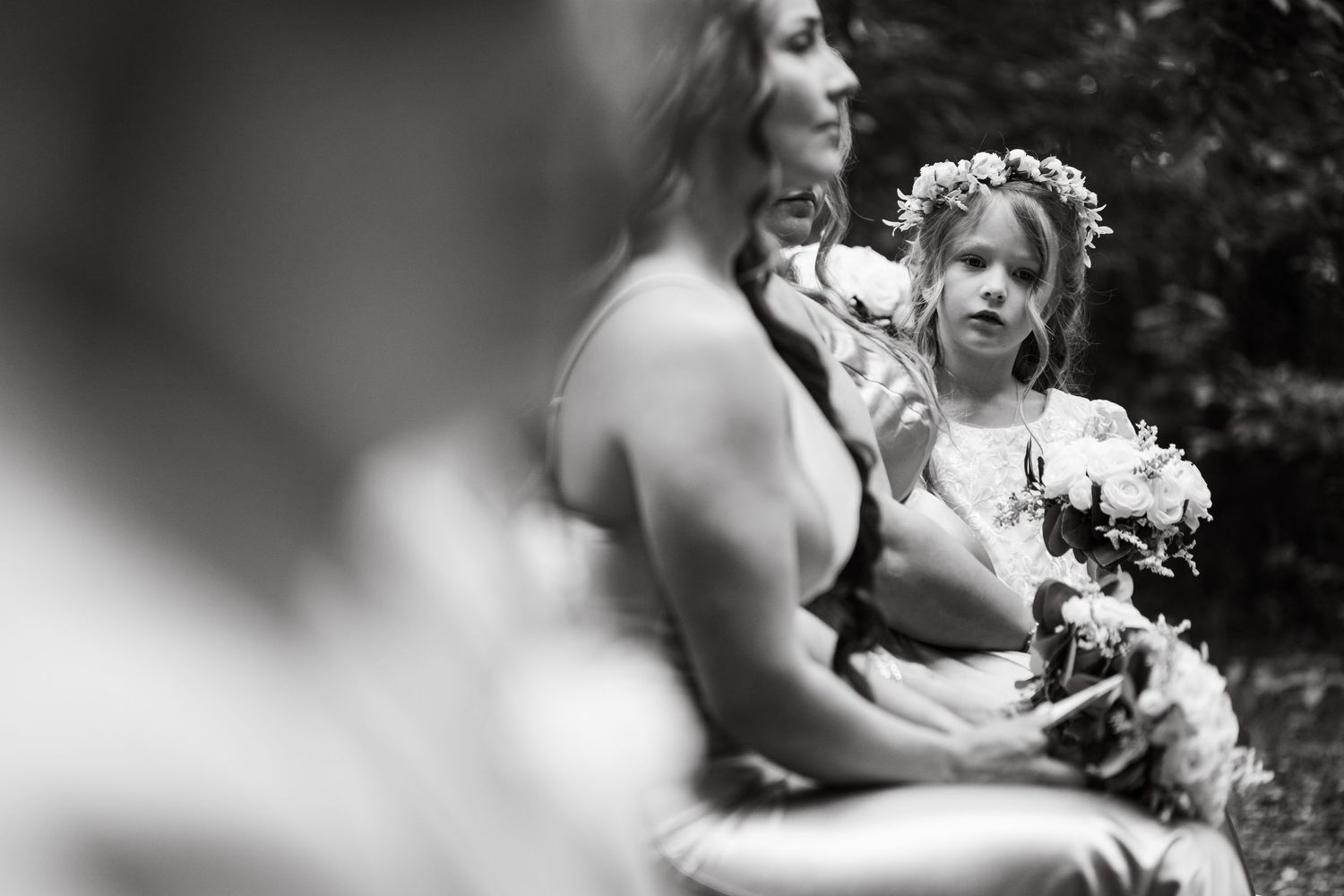 Black and white wedding ceremony moments in a wooded outdoor setting.