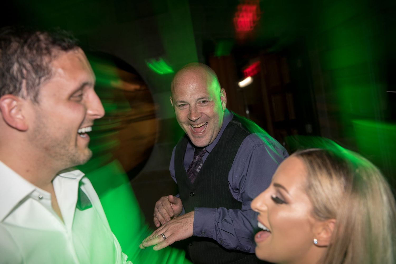 Dance party scene with dramatic green lighting creating a festive atmosphere.