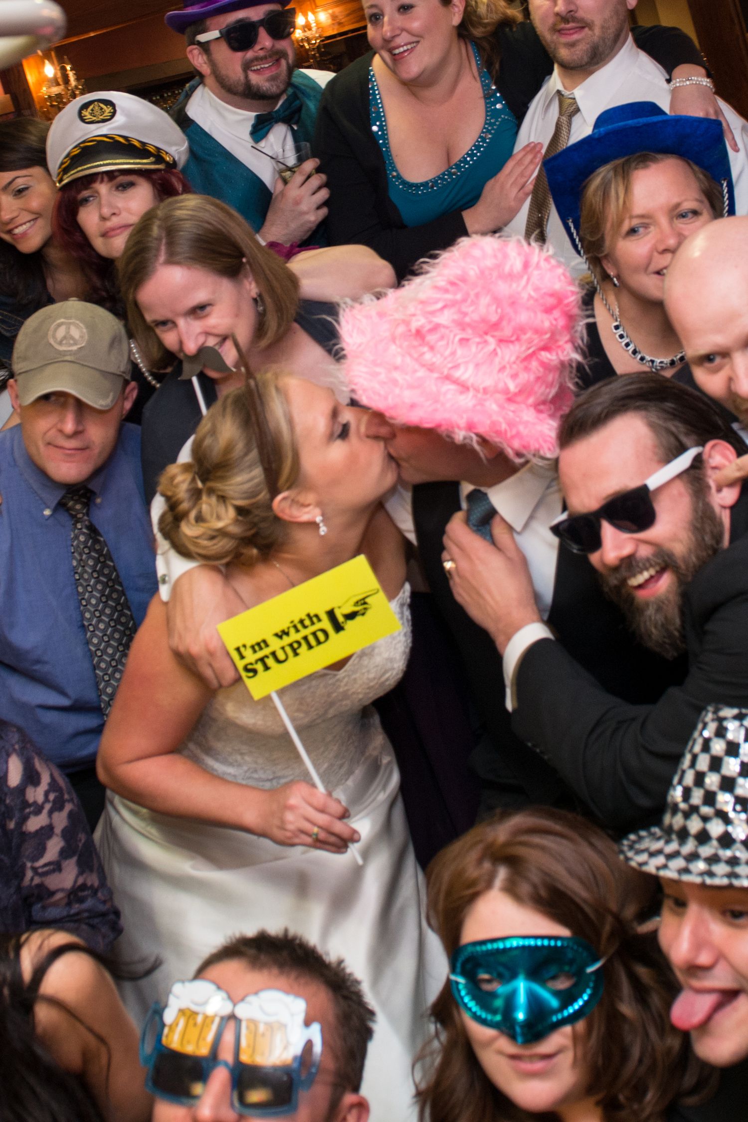 Large group of party guests wearing sunglasses and props while celebrating together.