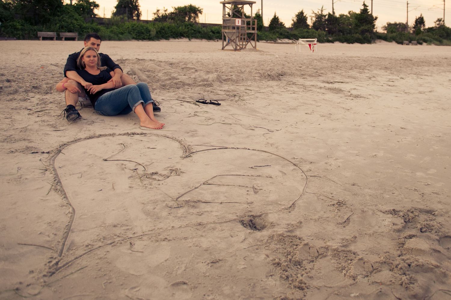 A series of playful drawings created in beach sand showing progression of artwork.