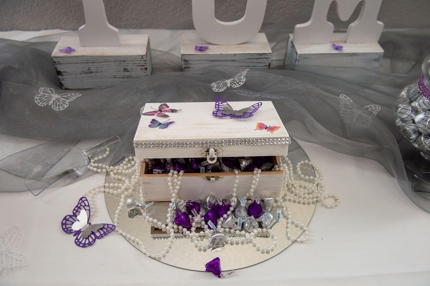 Purple butterfly decorations and lace details adorn a formal event setting.