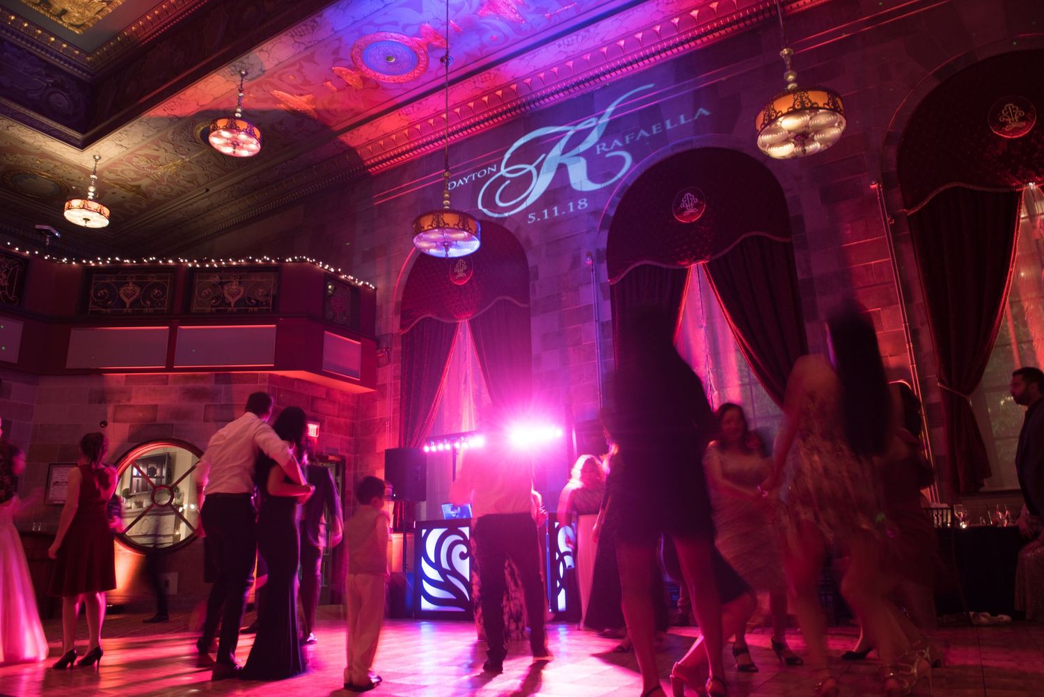 Wedding venue decorated with disco balls and illuminated by dramatic red and purple lighting effects.