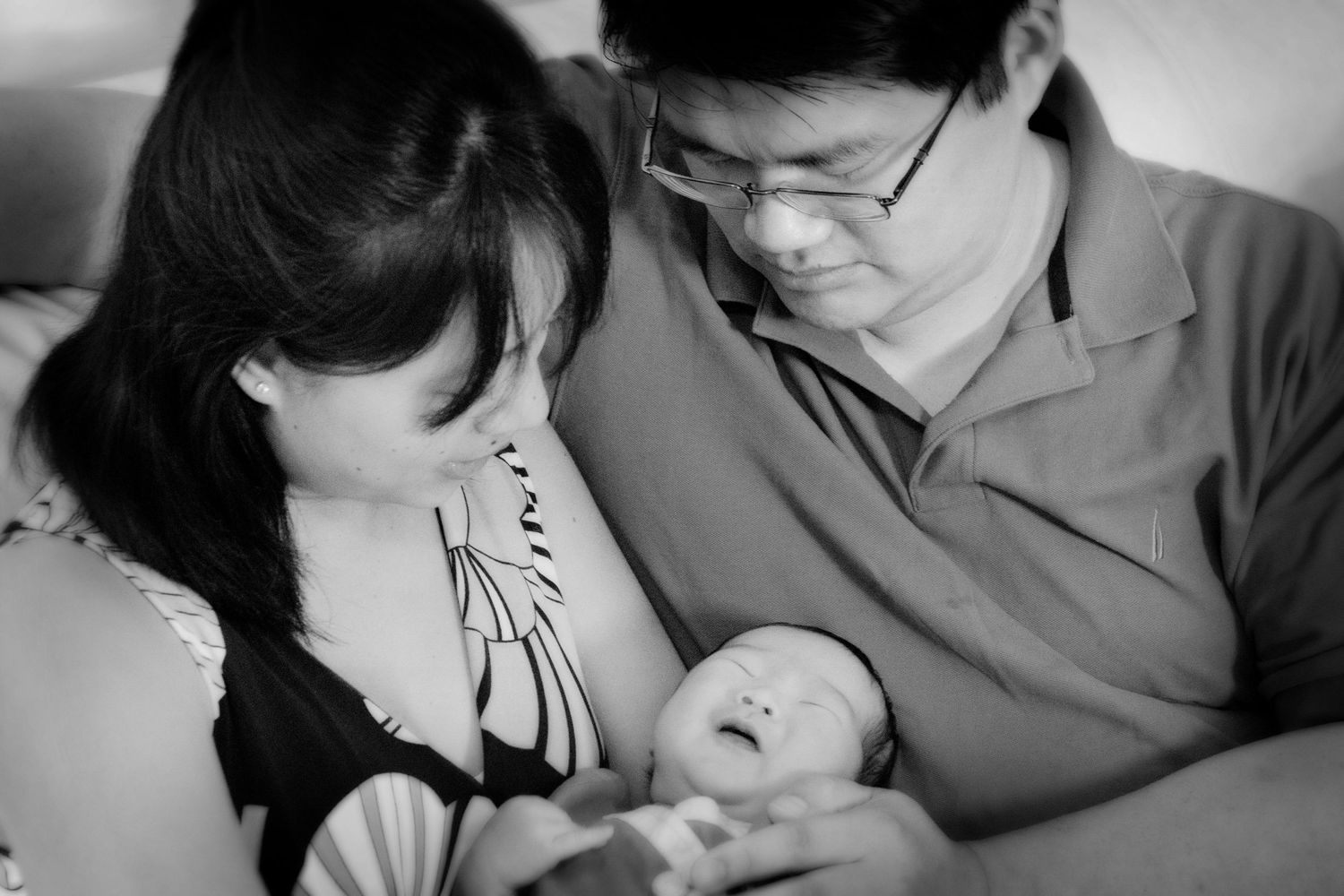 Black and white candid moment of parents with their newborn.