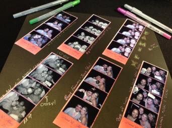 Photo booth strips arranged in a fan pattern on dark surface.