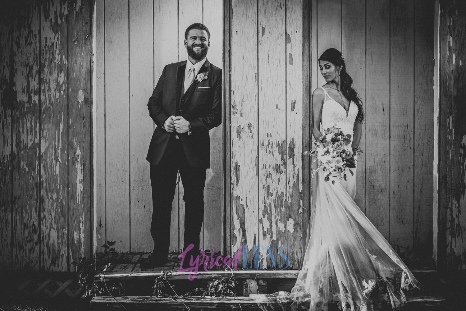 Wedding portraits against a rustic wooden wall backdrop in black and white.