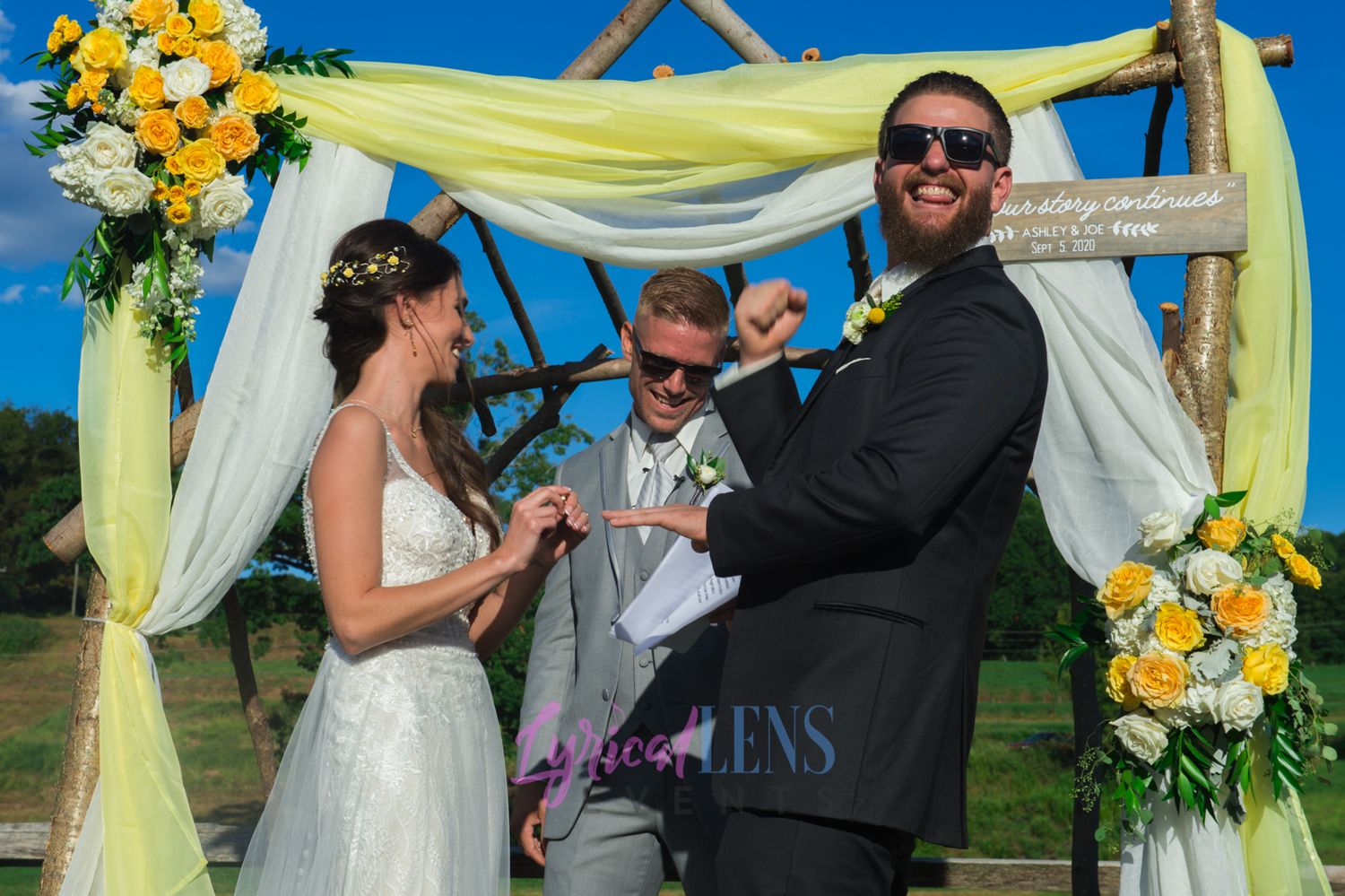 Outdoor wedding ceremony setup with yellow sunflowers and flowing yellow and white fabric decor.